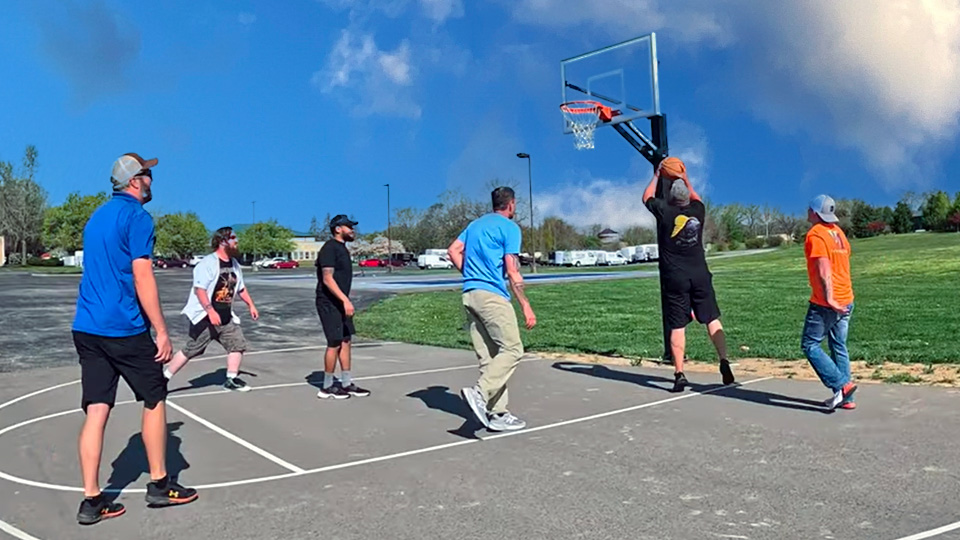 Van Martin Roofing employees paying a pickup game of basketball